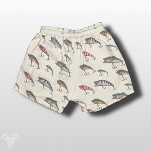 May include: White cotton shorts with a pattern of colorful fishing lures.