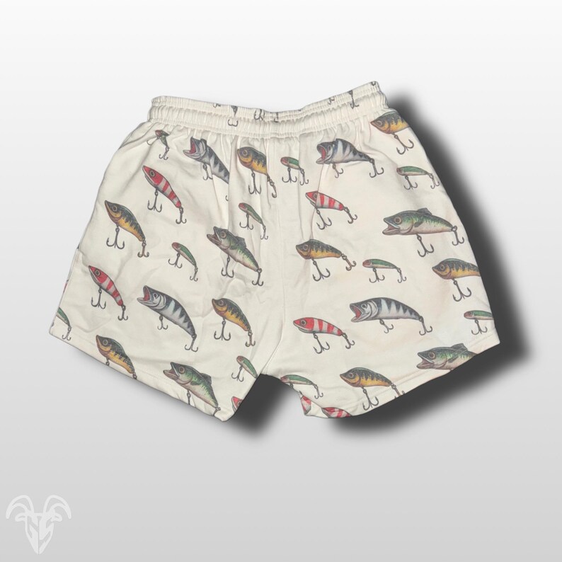 May include: White cotton shorts with a pattern of colorful fishing lures.