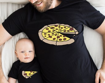 Könnte beinhalten: Ein schwarzes T-Shirt mit einem Pizzamuster. Ein Baby trägt einen passenden schwarzen Strampler mit einem Pizzastückmuster.