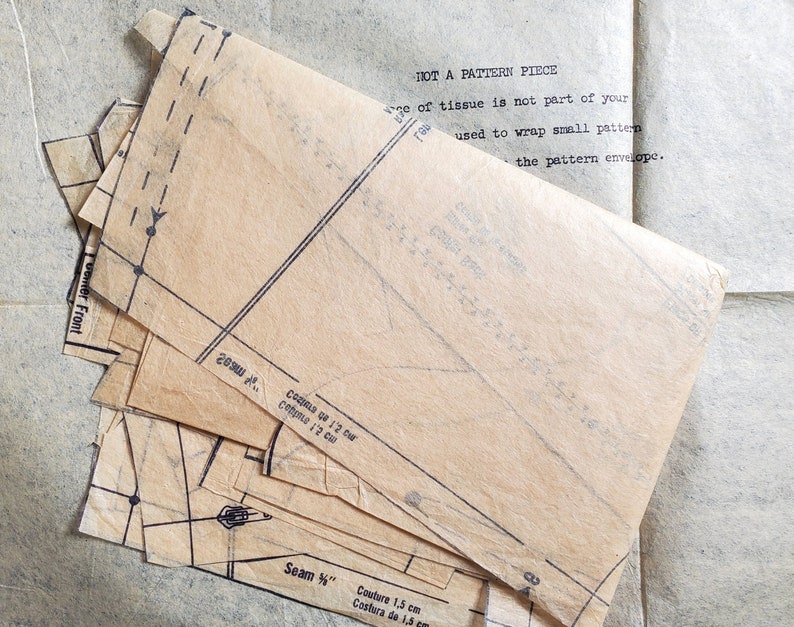 Puede incluir: Un conjunto de piezas de patr&oacute;n de papel marr&oacute;n con l&iacute;neas y marcas negras. El texto "NOT A PATTERN PIECE" es visible en la parte superior de la imagen. El texto "enter Front" es visible en el lado izquierdo de la imagen. El texto "Seam 1/4" es visible en la parte inferior de la imagen.
