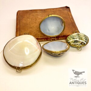 Vintage Sea Shell Coin Purses/Pill Boxes, Victorian Style With Brass Frames, Set of 3, ca. 1960s - 70s. Crafted from three different sea shells in three DIFFERENT SIZES, these LOVELY COIN PURSES or PILL BOXES would make lovely DECORATOR ITEMS in any bedroom or bathroom, especially for a BEACHFRONT PROPERTY. The large shell is 3-1/4 in. from front to back; the medium shell 2-1/4 in., and the small shell is 1-3/4 in. front to back. Price: $75 with FREE SHIPPING.