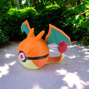 May include: Orange and yellow 3D printed Pokemon figure with green wings and a red tail. The figure is posed with its wings spread out and its tail curled up.
