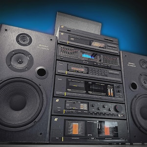 May include: A vintage stereo system featuring two large black speakers and a stack of black audio components. The components include a tuner, amplifier, and cassette deck. The background has a blue and black gradient.