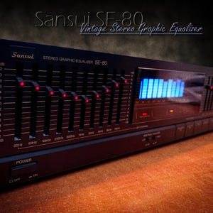 Könnte beinhalten: Ein Vintage Sansui SE-80 Stereo-Grafik-Equalizer. Das schwarze Gerät verfügt über mehrere Schieberegler mit roten Kontrollleuchten, ein blaues LED-Display und Bedientasten. Der Text auf dem Gerät enthält "Sansui", "Stereo Graphic Equalizer SE-80" und Frequenzmarkierungen.
