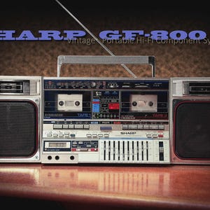 May include: Vintage Sharp GF-800 portable hi-fi component system. The silver boombox features two cassette decks, a digital display, and a series of equalizer sliders. The speakers have black mesh covers. The text "SHARP GF-800" is displayed in blue.