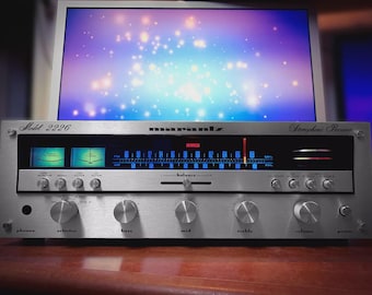 May include: Silver Marantz Model 2226 stereo receiver with multiple knobs and dials. The receiver has a blue and green display and the word "Marantz" is printed across the top. The background is a computer monitor displaying a colourful, starry image.
