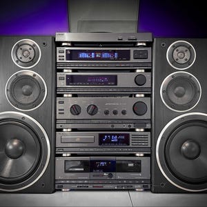 May include: A classic stereo system with two large black speakers and a stack of silver audio components. The system includes a turntable, amplifier, CD player, and cassette deck, all with digital displays. The Sony logo is visible on the speakers and components.