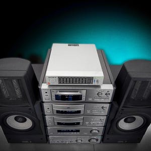 Puede incluir: Un sistema est&eacute;reo vintage con un ecualizador blanco y m&uacute;ltiples componentes plateados apilados. Dos grandes altavoces negros flanquean el sistema. La configuraci&oacute;n est&aacute; contra un fondo verde azulado oscuro.