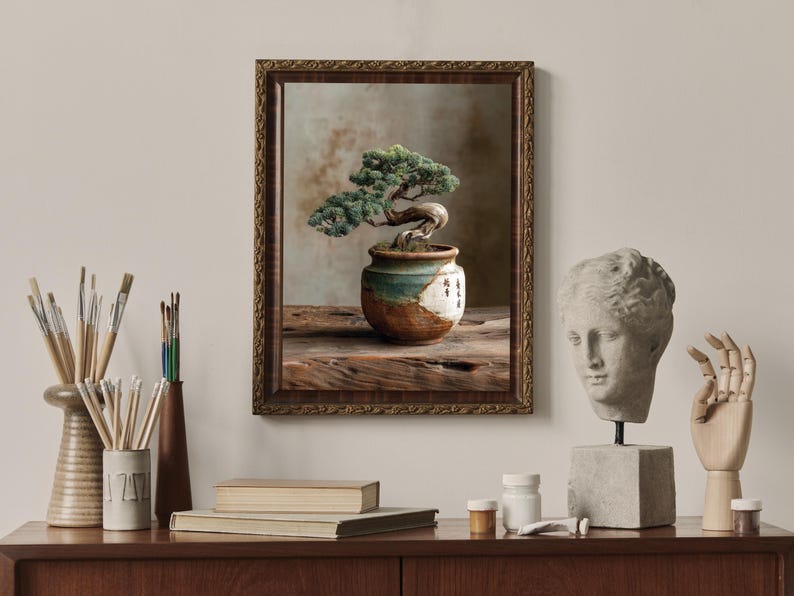 May include: A framed picture of a bonsai tree in a decorative pot. The pot is placed on a wooden surface. The image is surrounded by art supplies, a bust, and a wooden hand.