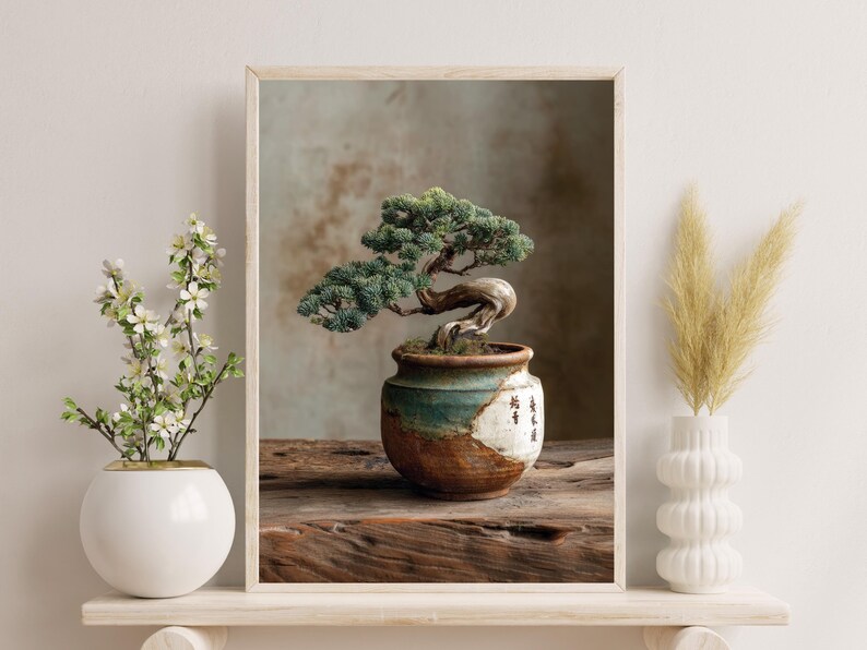 May include: A framed print of a bonsai tree in a ceramic pot. The tree has green foliage and a twisted trunk. The pot is brown and teal, with Japanese characters. The print is on a wooden surface.