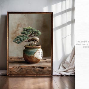 May include: A framed print of a bonsai tree in a ceramic pot. The tree has green leaves and a curved trunk. The pot is brown, white, and teal. The print is on a wooden table with the text "Where walls tell stories and spaces inspire".