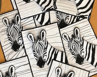 May include: A collection of rectangular cards featuring a black and white illustration of a zebra head. Each card displays a zebra with distinct stripes against a background of horizontal lines, with a black border framing the artwork.