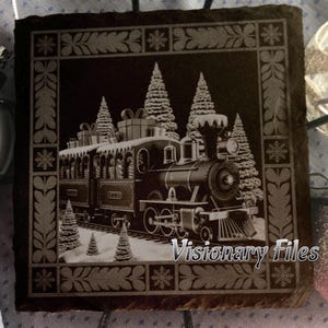 May include: A black square slate coaster with a detailed engraving of a vintage Christmas train. The train is surrounded by snow-covered pine trees and snowflakes. The text "Visionary Files" is at the bottom.