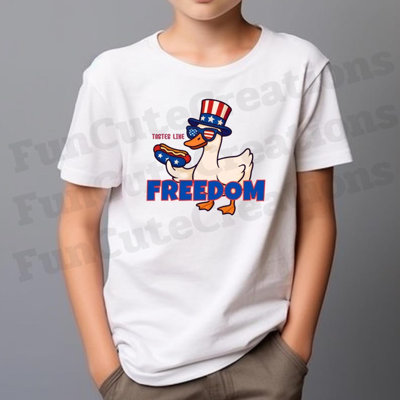 May include: White t-shirt featuring a cartoon duck wearing sunglasses and a patriotic hat, holding a hot dog. The word "FREEDOM" is displayed in blue block letters below the duck. The text "TASTES LINE" is above the hot dog.