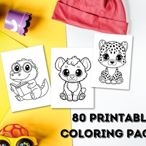 Op de afbeelding: Drie afdrukbare kleurplaten met cartoon dieren: een dinosaurus die leest, een hyena en een luipaard. De tekst "80 PRINTABLE COLORING PAGES" wordt weergegeven. Kleurpotloden en speelgoed liggen verspreid.
