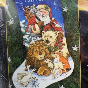 Könnte beinhalten: Ein Weihnachtsstrumpf mit dem Namen "Christina" bestickt. Der Weihnachtsmann ist mit einem Eisbären, einem Löwen, einem Fuchs, einem Lamm und zwei Gänsen dargestellt. Der Strumpf ist mit einem blauen Hintergrund und Sternen verziert.