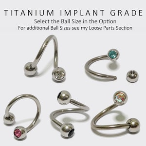 May include: Six titanium implant grade body jewelry pieces with different colored gem stones. The jewelry is in the shape of a curved barbell with a ball on each end. The gem stones are blue, clear, black, pink, and iridescent.