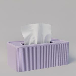 Könnte beinhalten: Eine rechteckige, lavendelfarbene Taschentuchbox mit vertikalen Rippendetails. Weiße Taschentücher ragen aus der oberen Öffnung heraus. Die Box hat eine einfarbige Farbe und steht auf einem schlichten, hellen Hintergrund.