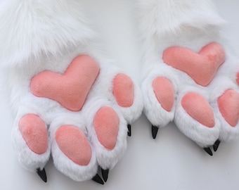 Patas peludas blancas de cuatro dedos, patas de piel con almohadillas de color rosa salmón