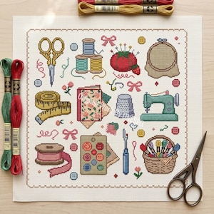 May include: A square cross-stitch pattern on white fabric featuring sewing motifs including gold scissors, colorful thread spools, a red pincushion, a wooden hoop, a yellow measuring tape, a thimble, a green sewing machine, and a basket of thread.