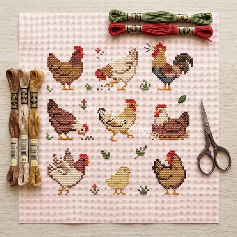 May include: A cross-stitch project featuring various chickens and a rooster in shades of brown, red, and yellow. Embroidery floss in green, red, and brown, along with scissors, are also visible. The design is on a pink canvas.