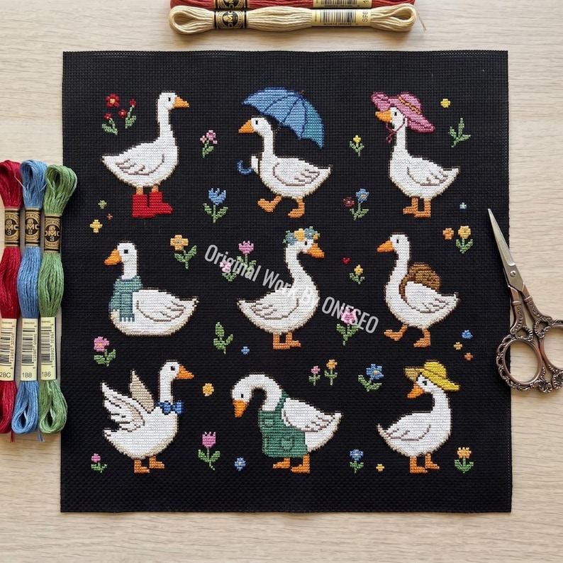 May include: Cross-stitch pattern featuring nine white geese, each adorned with unique accessories like hats, scarves, and an umbrella, set against a black background with floral accents. The text "Original World ONESEO" is visible.