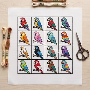May include: A white Aida fabric square featuring a cross-stitch pattern of sixteen distinct parrots arranged in a four-by-four grid. Each parrot is perched on a branch. Embroidery floss in beige and brown tones and metal scissors are included.