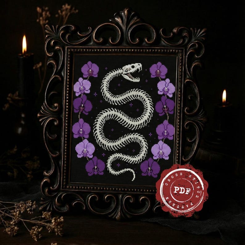 May include: Cross-stitch pattern featuring a white snake skeleton design on a black background, framed by purple orchids. The framed artwork is in a dark, ornate frame. A red PDF stamp is in the lower right corner.