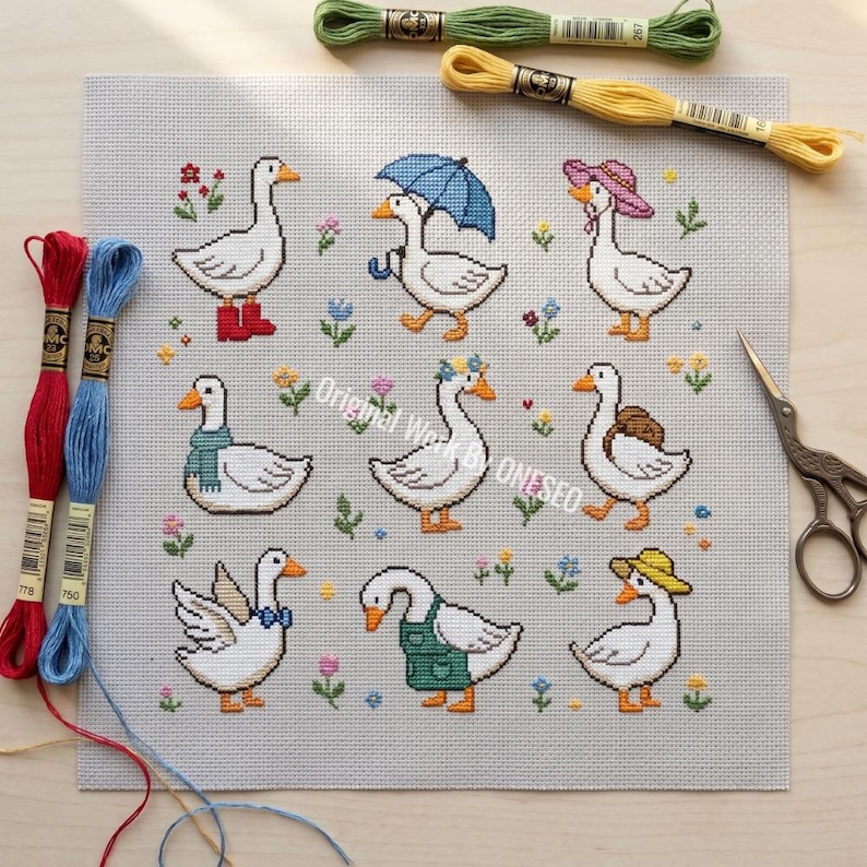 May include: A cross-stitch pattern featuring nine whimsical geese, each adorned with unique accessories like boots, hats, and a backpack. The geese are set against a light gray background with floral accents. Embroidery floss and scissors are also visible.
