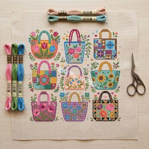 Puede incluir: Un patr&oacute;n de punto de cruz sobre tela beige que muestra nueve bolsos con dise&ntilde;os florales y geom&eacute;tricos. El conjunto incluye cinco madejas de hilo de bordar sueltas en rosa, verde y azul, y unas tijeras de bordar de metal.
