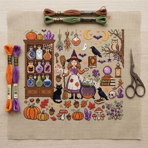 May include: A cross-stitch pattern on beige fabric featuring a central witch figure, a potion cabinet, a cauldron, an owl, ravens, pumpkins, mushrooms, and crystals. The kit includes two skeins of orange and purple embroidery floss and scissors.