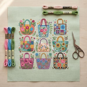 Puede incluir: Un cuadrado de tela verde claro con un patr&oacute;n de punto de cruz de nueve bolsos decorados con dise&ntilde;os florales y geom&eacute;tricos. La pieza se acompa&ntilde;a de seis madejas de hilo de bordar de colores y un par de tijeras de estilo vintage.