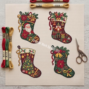 Könnte beinhalten: Ein Kreuzstichmuster auf beigem Stoff mit vier Weihnachtssocken. Eine zeigt den Weihnachtsmann, eine einen Nussknacker, eine einen geschmückten Baum und eine Weihnachtssterne mit Glocken. Drei Stickgarnstränge und eine Metallschere liegen bei.