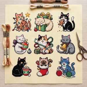 Op de afbeelding: Een kruissteekpatroon op crèmekleurige stof met negen feestelijke katten, waaronder een verstrikt in lichtjes, een op een cadeau en een met een peperkoekmannetje. Inclusief twee strengen borduurgaren en een metalen schaar.