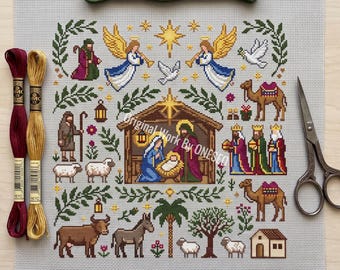 May include: A cross-stitch pattern on light grey Aida fabric featuring a nativity scene with a central stable, angels, camels, sheep, and the three wise men. The design includes a palm tree, stars, and doves. Three skeins of embroidery floss and scissors are placed nearby.