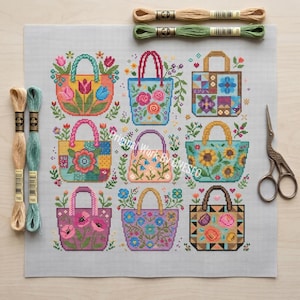 Puede incluir: Un patr&oacute;n de punto de cruz sobre tela blanca con nueve bolsos coloridos con dise&ntilde;os florales y geom&eacute;tricos. El conjunto incluye cuatro madejas de hilo de bordar en beige y verde, y unas tijeras de bordar de metal de estilo vintage.