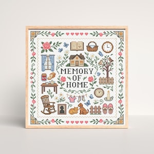 Può includere: Un'opera d'arte a punto croce incorniciata con una cornice in legno. Il design presenta una casa, fiori, farfalle e le parole "MEMORY OF HOME". Altri elementi includono una sedia a dondolo, un orologio e un gatto e un cane.