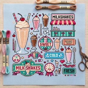Puede incluir: Una tela de punto de cruz azul claro con un patrón colorido de batidos, cerezas y letreros de estilo retro con el texto MILKSHAKES, SWEET, COLD, DESSERT TICKET y FRESH, acompañada de madejas de hilo de bordar y tijeras de metal.