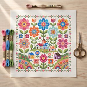 Può includere: Un colorato motivo a punto croce con fiori e case. Il design presenta fiori rosa, blu, arancioni e viola, con foglie e steli verdi. Il testo "Work By ONES" è visibile. Sono presenti anche fili da ricamo e forbici.