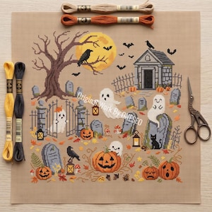 May include: A cross-stitch pattern on beige fabric featuring a graveyard scene with ghosts, pumpkins, tombstones, a tree, a mausoleum, and crows. The design includes lanterns, bats, and fallen leaves. Embroidery floss in yellow, black, tan, and orange, along with metal scissors, are placed around the fabric.