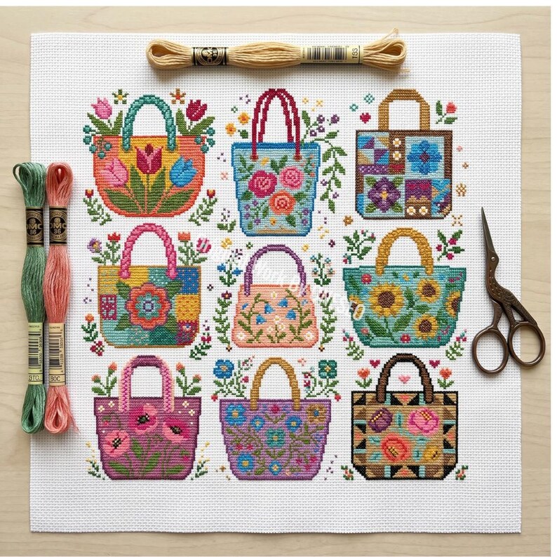Puede incluir: Un patr&oacute;n de punto de cruz sobre tela Aida blanca que muestra nueve bolsos con dise&ntilde;os florales y geom&eacute;tricos. El kit incluye tres madejas de hilo de bordar en beige, verde y rosa, junto con unas tijeras de metal de estilo vintage.