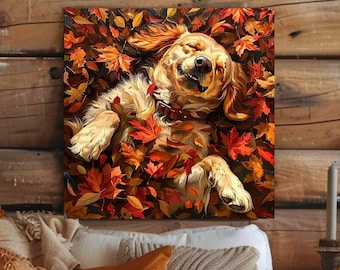 May include: A square wall art print featuring a golden-coloured dog with a dark collar lying on its back, eyes closed in a joyful expression, surrounded by a dense pile of vibrant orange, red, and yellow autumn maple leaves in a forest setting.