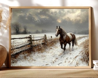 May include: A framed wall art print depicting a brown and white horse standing in a snow-covered field. A rustic wooden fence runs along the left side of the landscape under a cloudy, overcast sky with light snowfall visible across the scene.