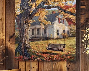May include: A square wall art print depicting a white house with a gray roof and red shutters, situated behind a large tree with yellow autumn leaves. A dark wooden porch swing hangs from a thick tree branch over a lawn covered in fallen leaves.