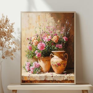 Könnte beinhalten: Gerahmtes Gemälde mit zwei Terrakotta-Vasen, gefüllt mit rosa und pfirsichfarbenen Blumen. Die Vasen stehen auf einem steinernen Sims vor einer strukturierten beigefarbenen Wand. Das Gemälde hat eine warme Farbpalette.