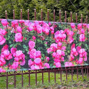 May include: A pink rose bush printed on a mesh fence panel. The panel is attached to a metal fence with brown posts.