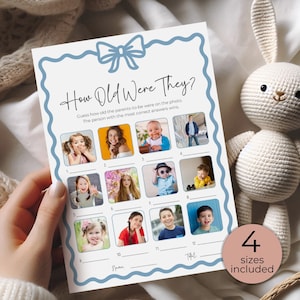 May include: A baby shower game card with a blue border and bow design. The card features the text "How Old Were They?" and includes spaces for guessing the parents' ages in photos. A crocheted bunny is in the background.