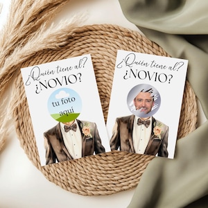 May include: Two white cards with the text "¿Quién tiene al? ¿NOVIO?" in black script. One card has a blue and green circle with the text "tu foto aquí". The other card has a photo of a man. Both cards feature a watercolor illustration of a man in a tuxedo.