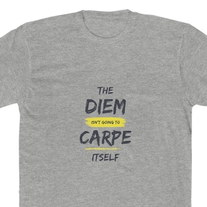May include: A heather gray t-shirt with the text "THE DIEM ISN'T GOING TO CARPE ITSELF" in a black, yellow, and white design. The shirt has a crew neck and short sleeves.