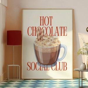 Könnte beinhalten: Gerahmtes Poster mit einer Grafik von heißer Schokolade mit Marshmallows und einem Waffelröllchen. Die Worte "HOT CHOCOLATE SOCIAL CLUB" sind in roter Schrift. Das Poster befindet sich in einem Raum mit einer roten Lampe und einem karierten Boden.